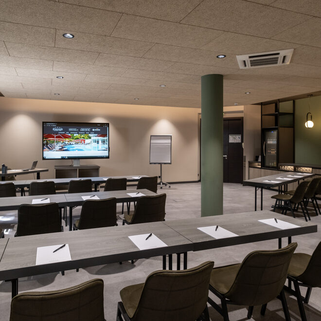 In einem großen Konferenzsaal mit moderner Ausstattung sind Tische aneinander gereiht Tagungsraum mieten für Tagungen, Workshops oder andere Events im 5 Sterne Hotel St. Wolfgang